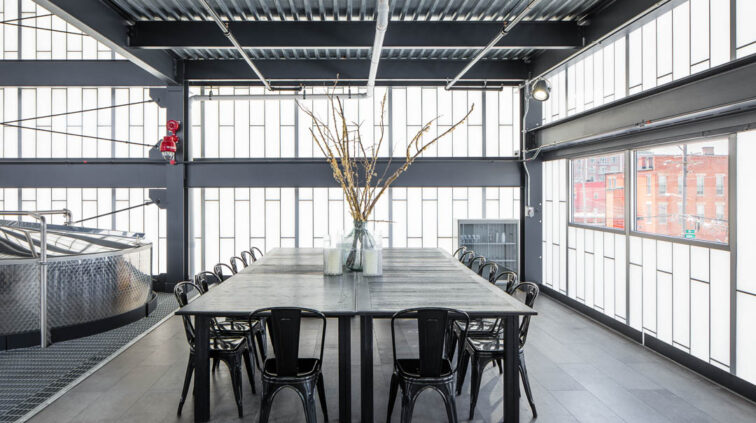 Interior photo of Middle West Spirits featuring a large group table and chairs.