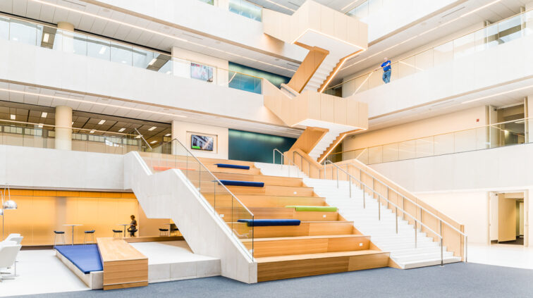 Interior photo of a large space with built in bench seating transitioning between the first and second floor in the OCLC Atrium in Columbus, Ohio.