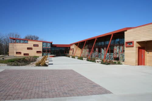 Exterior view of the Grange Audubon Center in Columbus, Ohio. A single-story building with stone exterior and a lobby with glass walls.