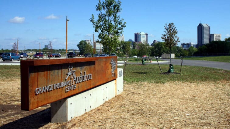 Exterior view of the Grange Audubon Center in Columbus, Ohio. A single-story building with stone exterior and a lobby with glass walls.