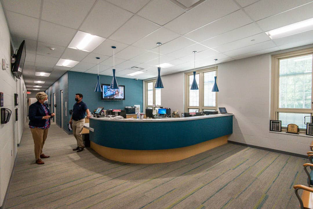Two people talk in the Kilbourne Middle Schools's office, inside the new secured entrance.