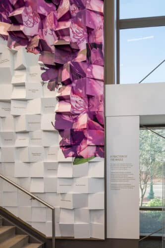 An interior image of the Kanawha Public Library in Charleston, West Virginia. Features a textured wall will a modern white and purple print on it.