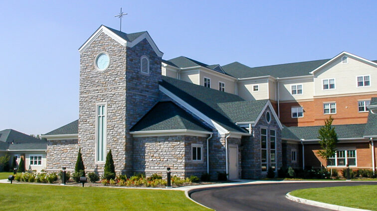 Exterior photo of Mother Angeline McCrory Manor, a nursing and assisted living facility in Columbus, Ohio. Features brick and stone exteriors on the multi-story building.