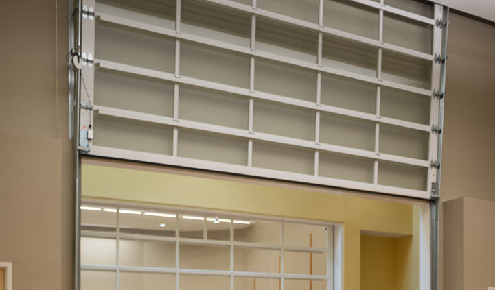 Interior photo of a classroom in Lynn Hall at Hanover College. Features long desks with chairs in front of a back wall that opens like a glass garage door.