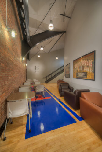 Photo of a common area in Lynn Hall at Hanover College. Features a vaulted ceilings and a brick wall, with comfortable seating for small groups.