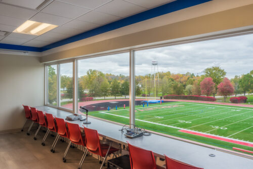 Interior view of the renovated Press Box in the Stadium at Hanover College. Photo is taken from behind the press desks, overlooking the stadium with large windows.