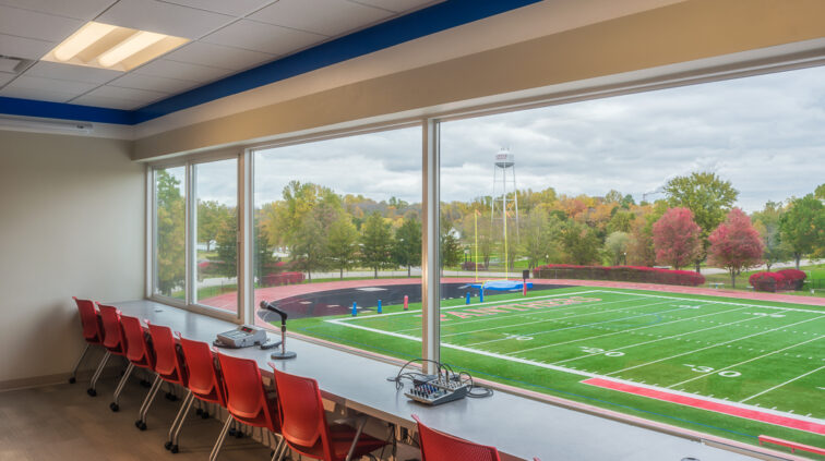Interior view of the renovated Press Box in the Stadium at Hanover College. Photo is taken from behind the press desks, overlooking the stadium with large windows.