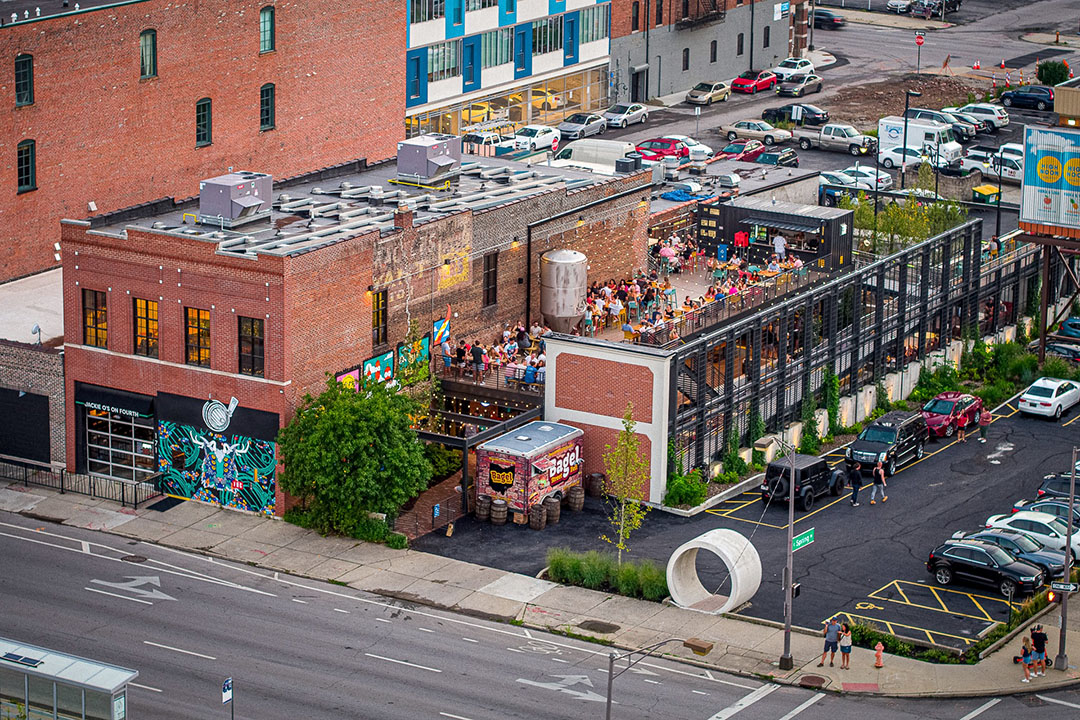 An aerial photo of Jackie O's brewery and patio on Fourth Street in Downtown Columbus. A two-story brick building with a metal patio on both floors.