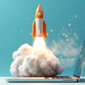 An AI image of an orange and white sleek looking rocket launching from the keyboard of an open silver laptop. Take on a team background and a white table.